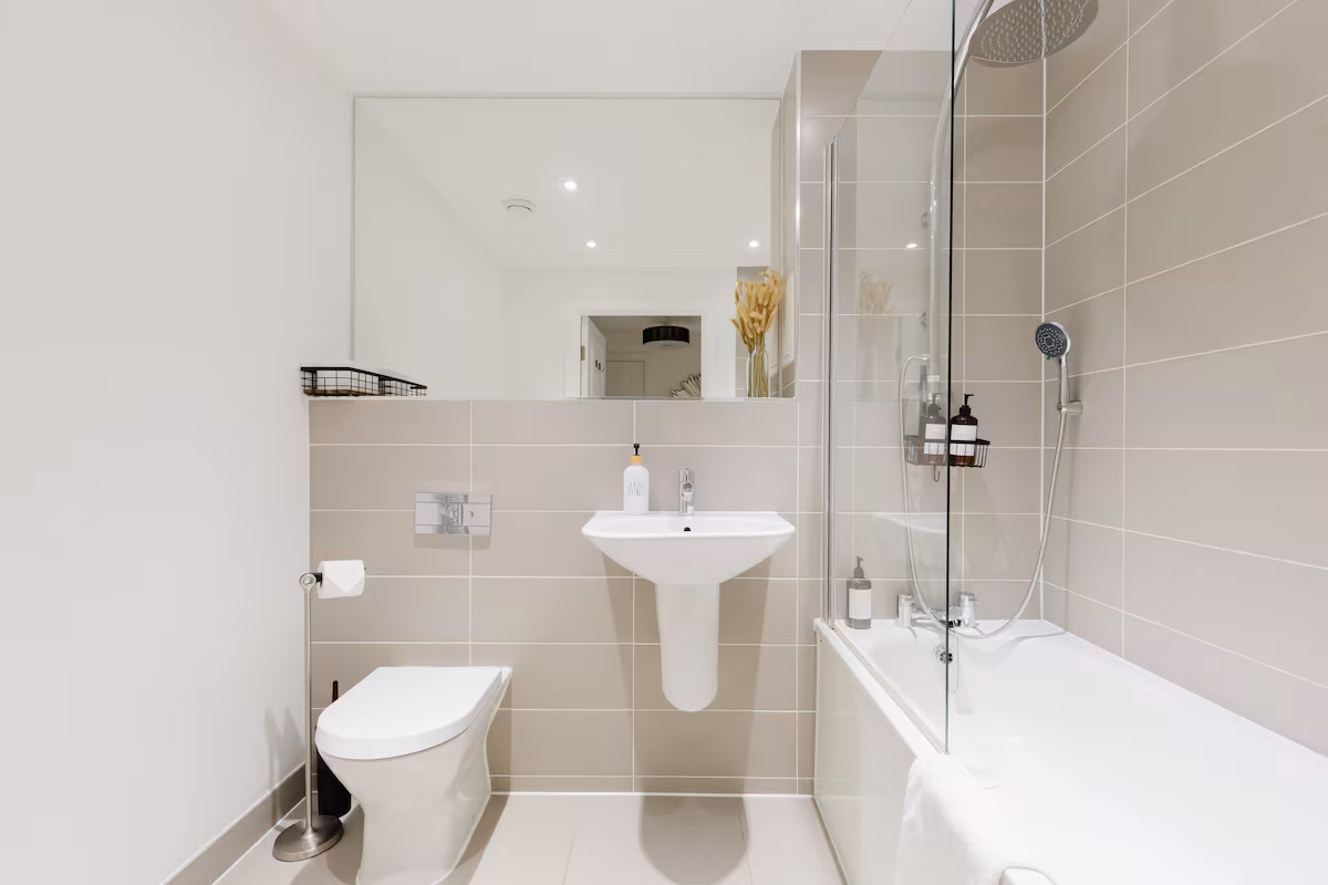 Bathroom with a full-size bath, glass screen and rainfall shower, basin and WC