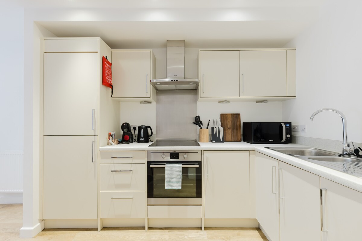 Fitted kitchen with oven and hob, extractor, fridge freezer, microwave and kettle